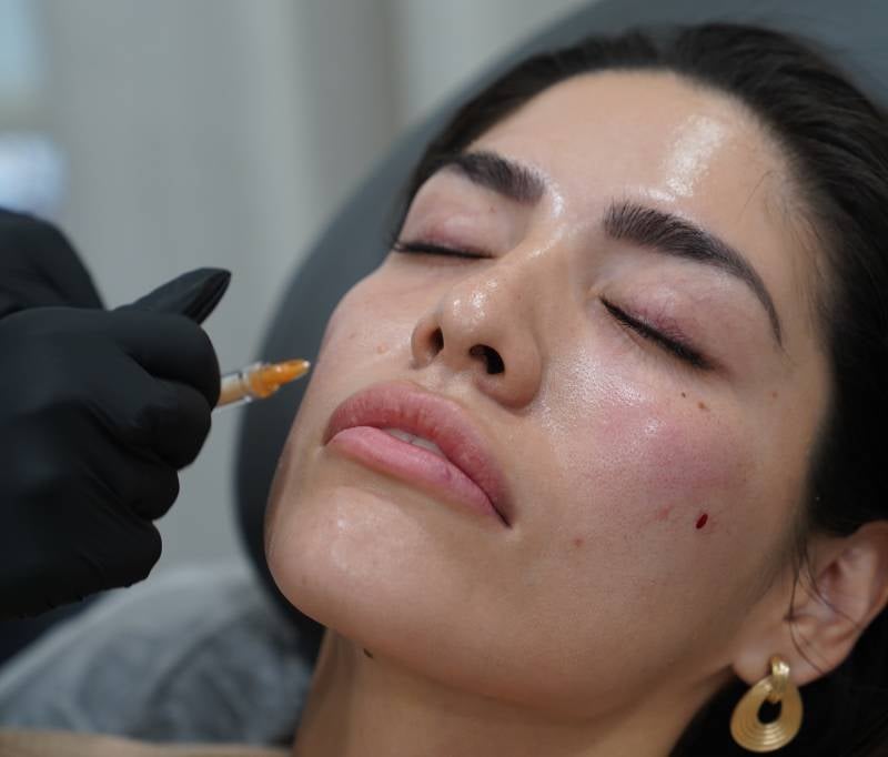 Woman getting face injection in her cheek